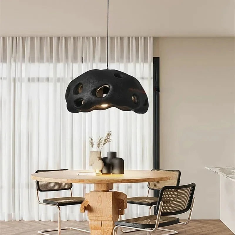 Black perforated dome above a wooden dining table