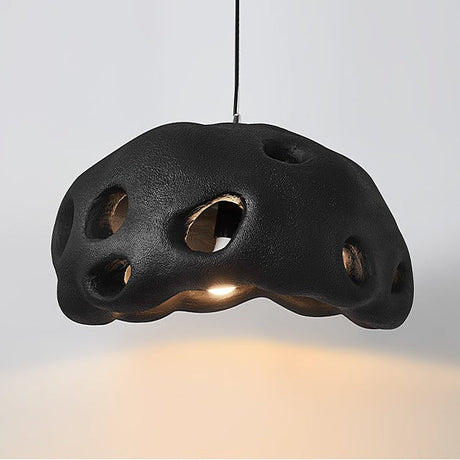 Black perforated dome shade photographed against a pale ground