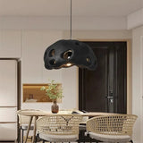 Black perforated dome above a kitchen table with woven chairs