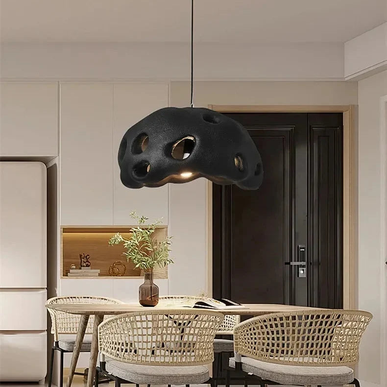 Black perforated dome above a kitchen table with woven chairs