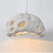 White perforated dome shade photographed against a pale ground