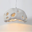 White perforated dome shade photographed against a pale ground