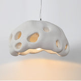 White perforated dome shade photographed against a pale ground