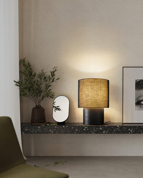 Wabi sabi table lamp unlit on a dark stone shelf beside objects