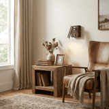 Reading lamp lit above a crate shelf beside an armchair with a throw