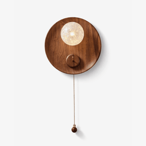 Wall lamp for reading, a walnut disc with a textured globe and a pull chain