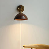 Close view of the lit walnut dome shade and its brass socket