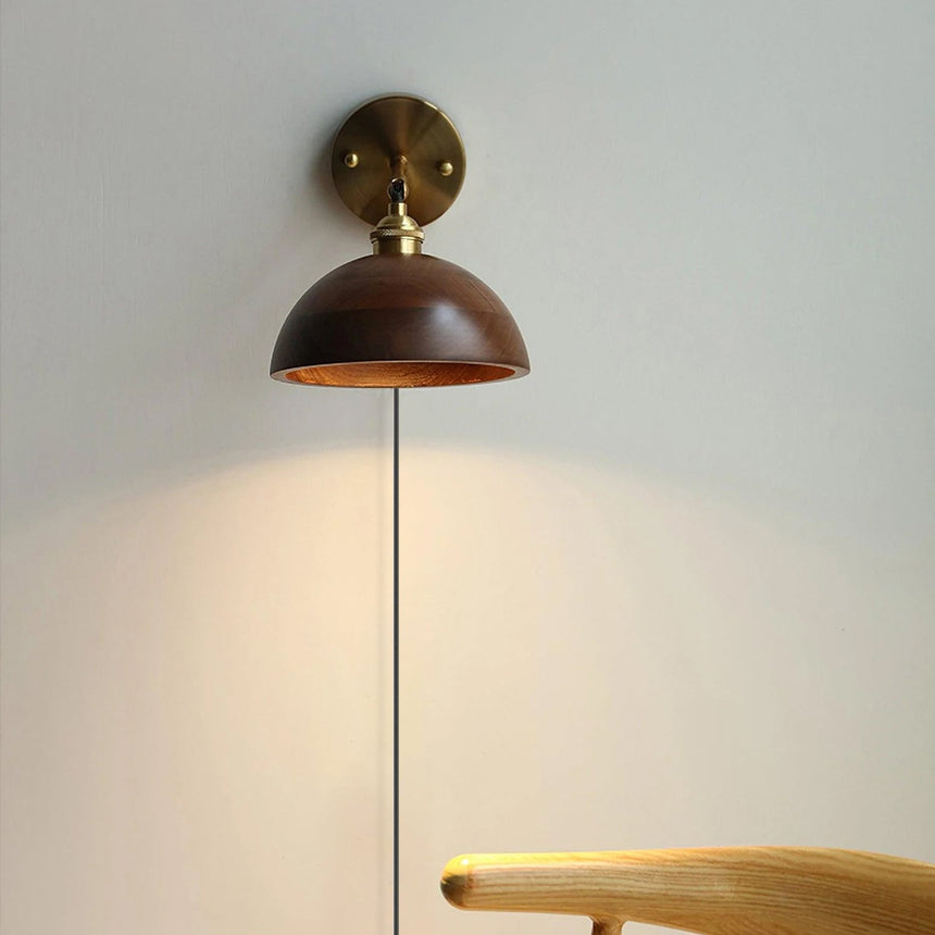 Close view of the lit walnut dome shade and its brass socket