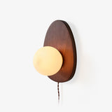 Oval walnut backplate with a white glass sphere set into its lower edge