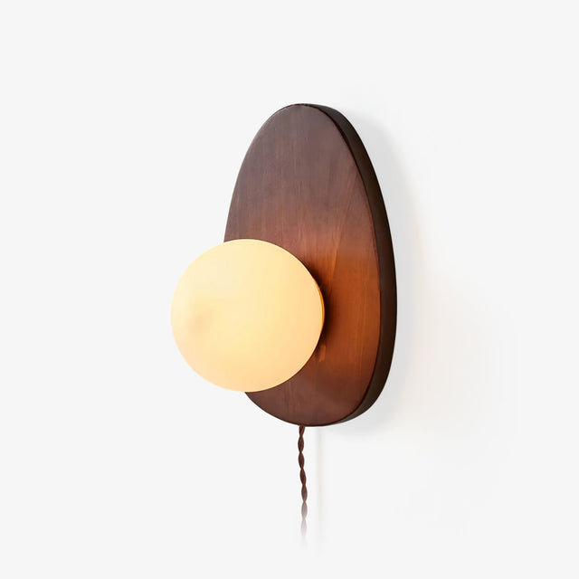 Oval walnut backplate with a white glass sphere set into its lower edge