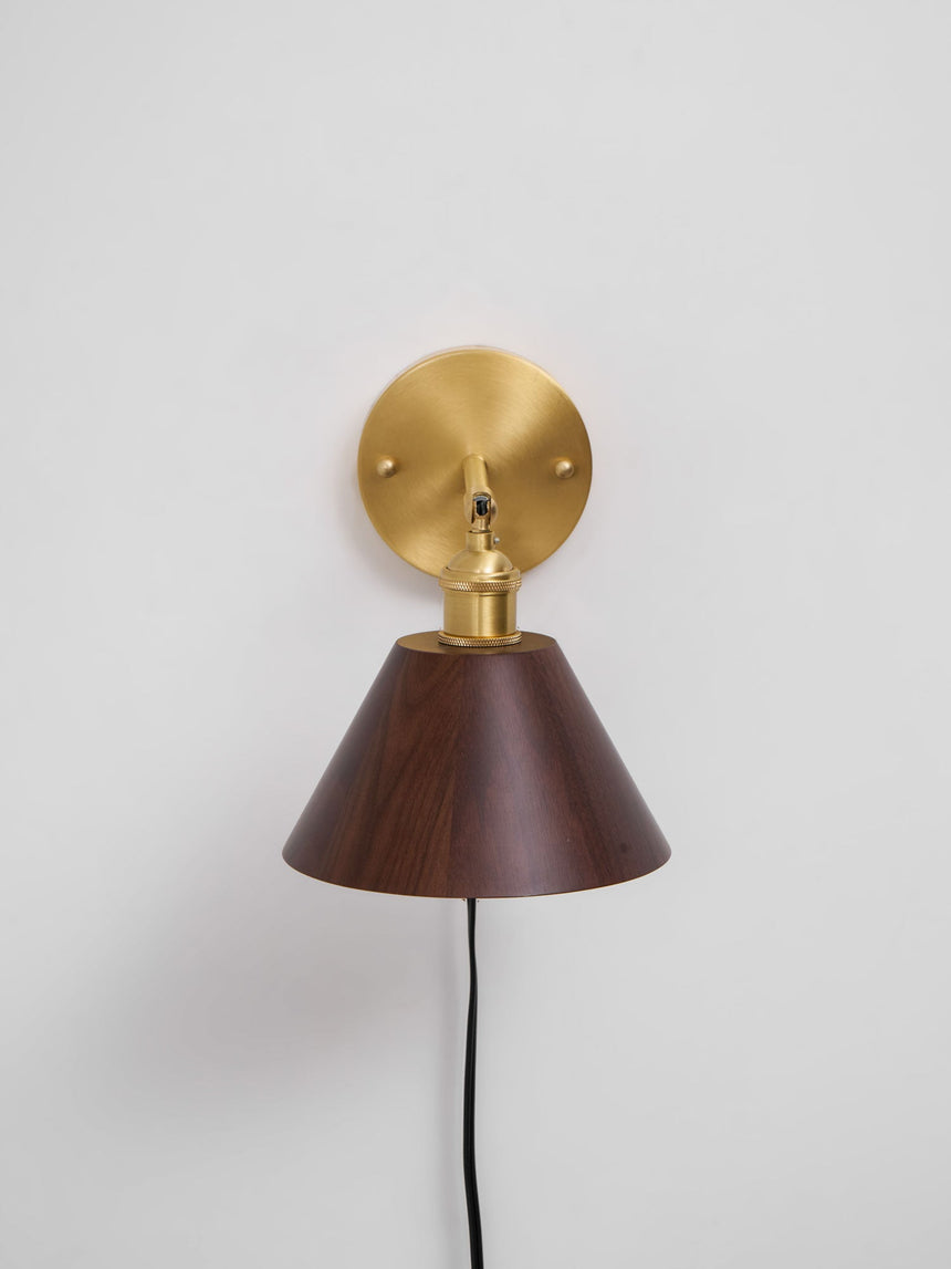 Close view of the round brass wall plate and the cord exit