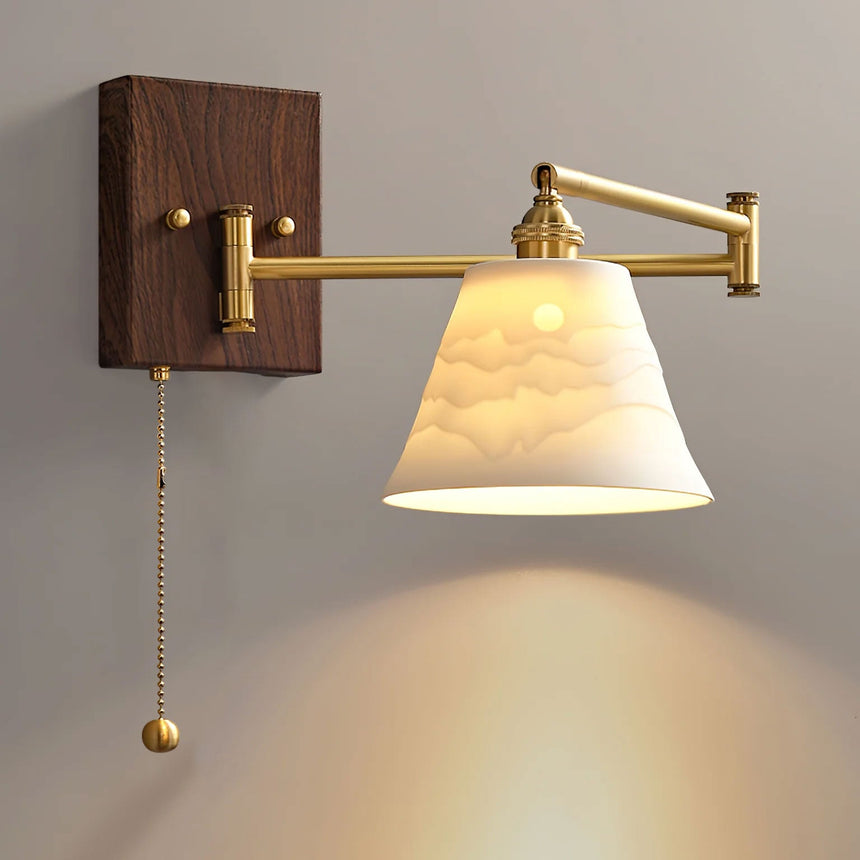 Fluted ceramic bell shade lit, throwing light down onto the wall