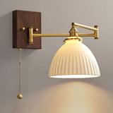 Wide rounded ceramic shade lit, seen from the side on a brass arm