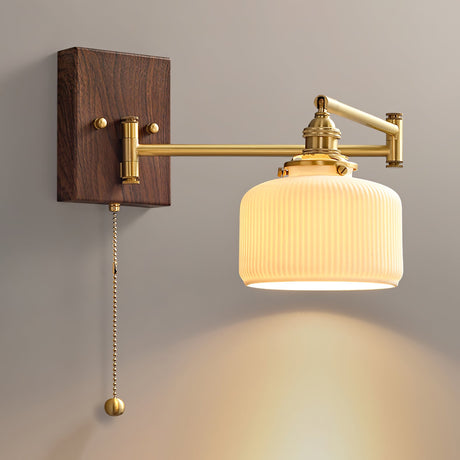 White ceramic shade lit on a brass arm over a dark walnut wall plate