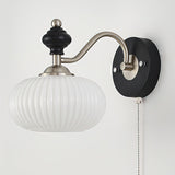 A fluted white glass shade seen from the front on the nickel arm