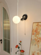 Lamp lit beside a large framed floral print in a corner of a room