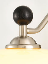 Close view of the wood ball finial where the nickel arm turns down