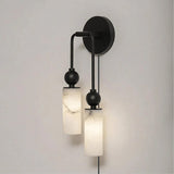 The black version with two lit stone tubes, seen on a pale wall