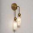 The brass version with two lit stone tubes, seen on a pale wall
