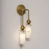 The brass version with two lit stone tubes, seen on a pale wall