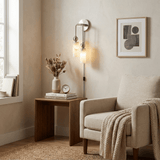 The lit lamp above a wood side table beside a cream armchair