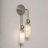 The nickel version with two lit stone tubes, seen on a pale wall