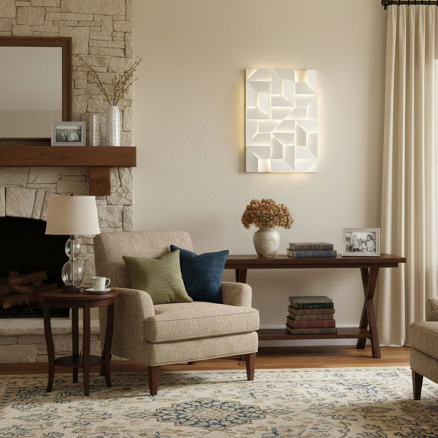 Lit above an armchair beside a stone fireplace with a mirror and a console