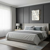 Lit above a bed with a gray headboard, a nightstand and a table lamp beside it