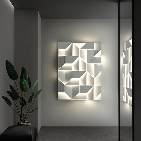 Lit on a dark wall beside a tall plant, light raking across the folded facets