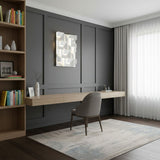Lit above a long desk in a study lined with dark wood paneling and open shelving