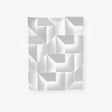 A large white panel of folded facets, the fitting switched off on a plain wall