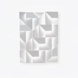 A large white panel of folded facets, the fitting switched off on a plain wall