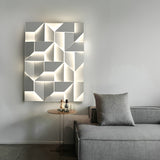 Lit above a gray sofa with a cushion and a small round side table alongside
