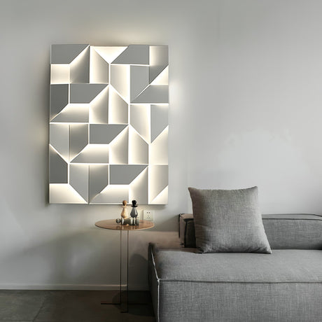 Lit above a gray sofa with a cushion and a small round side table alongside