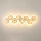Eight discs in a horizontal row, each glowing warm on a beige wall
