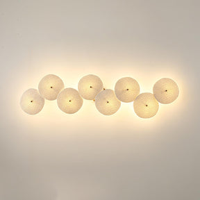 Eight discs in a horizontal row, each glowing warm on a beige wall