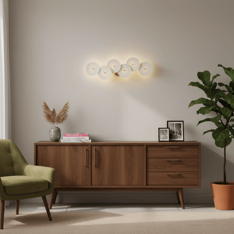 The disc light above a walnut sideboard and a green armchair