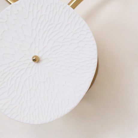 Close view of one ceramic disc, its surface pressed with a petal texture
