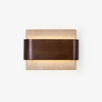 Wall sconce above bed, a travertine block wrapped by a walnut band