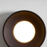 The white disc recessed deep inside the dark wood rim, lit from within