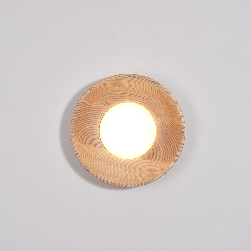 Light wood drum lit and seen at an angle, the beam grazing the wall