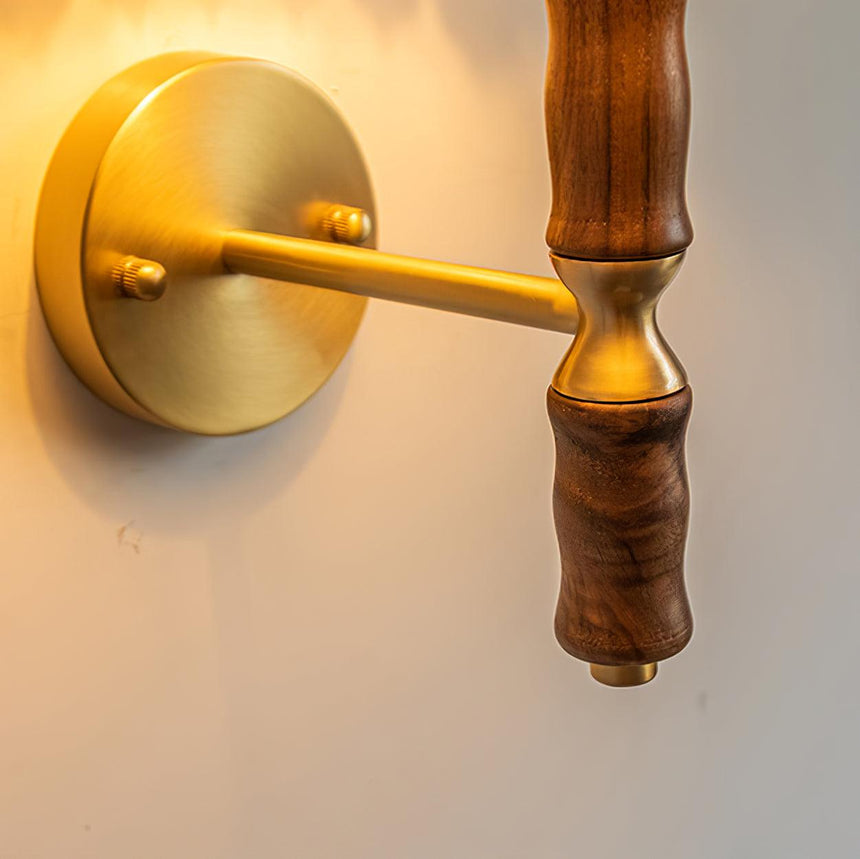 Close view of the round brass wall plate and the arm leaving it