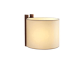 The wide beige shade curved around its wood post, seen unlit at an angle