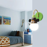 The monkey lamp lit on a pale wall beside a daybed and shelves
