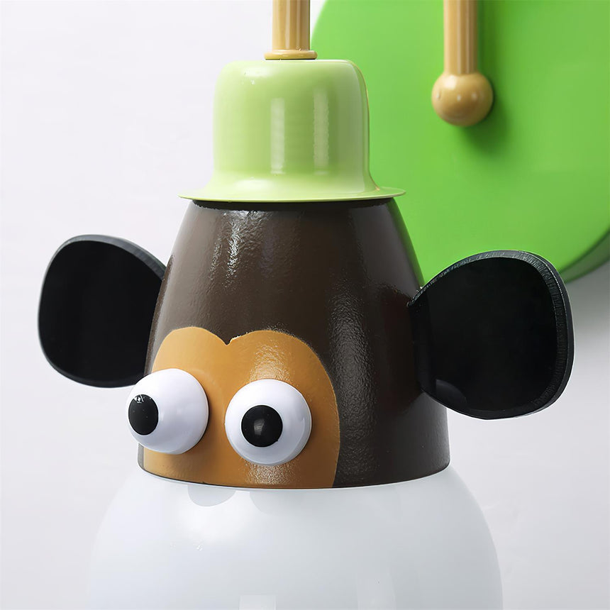 The monkey face seen close, the round ears and eyes above the bulb