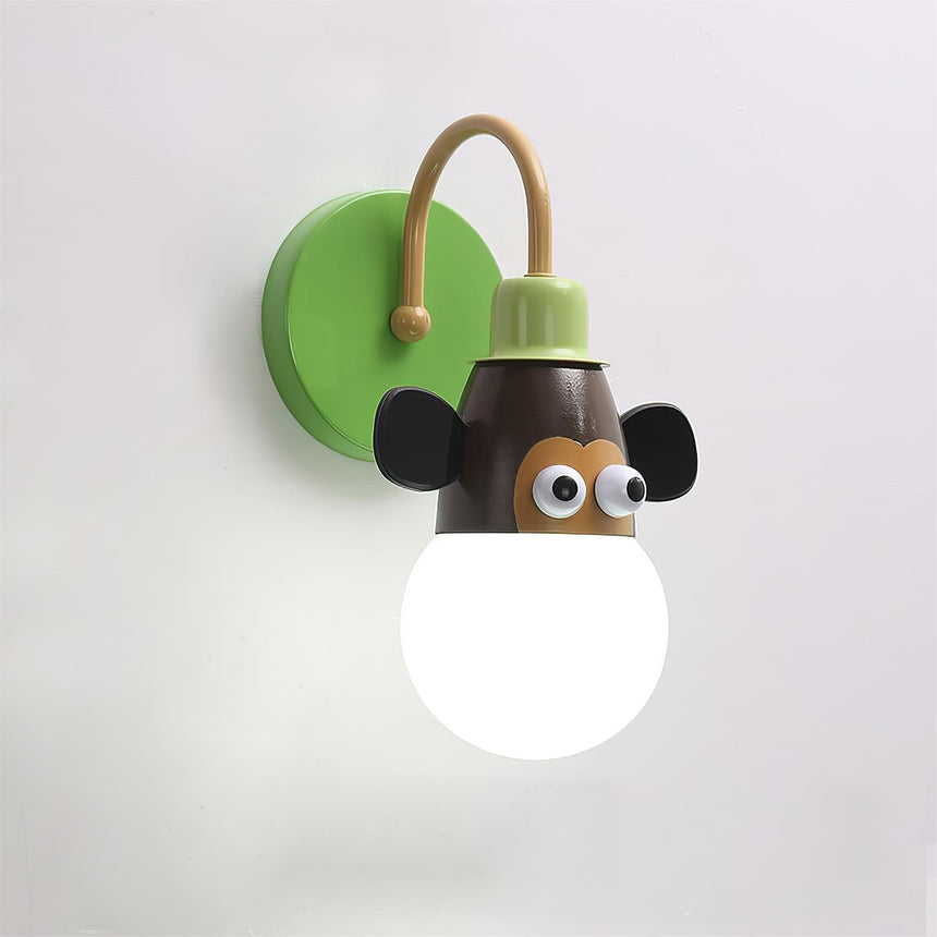 The green monkey lamp lit, its brown face with big ears and a green plate