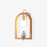 The bird model lit square on, the oak arch framing the glowing globe