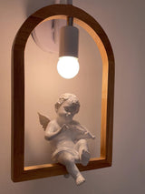 The winged figure lit from above, its face and wings catching the light