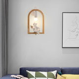 Sconce lit above a navy sofa with cushions beside a framed line drawing