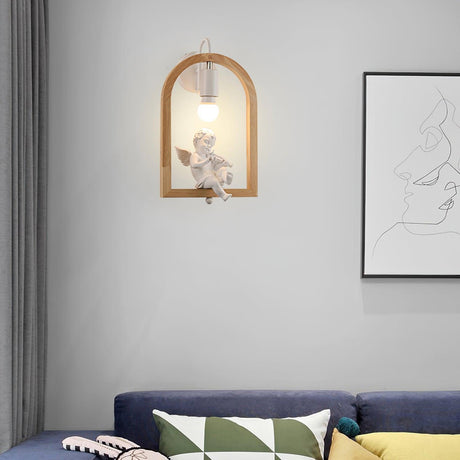 Sconce lit above a navy sofa with cushions beside a framed line drawing